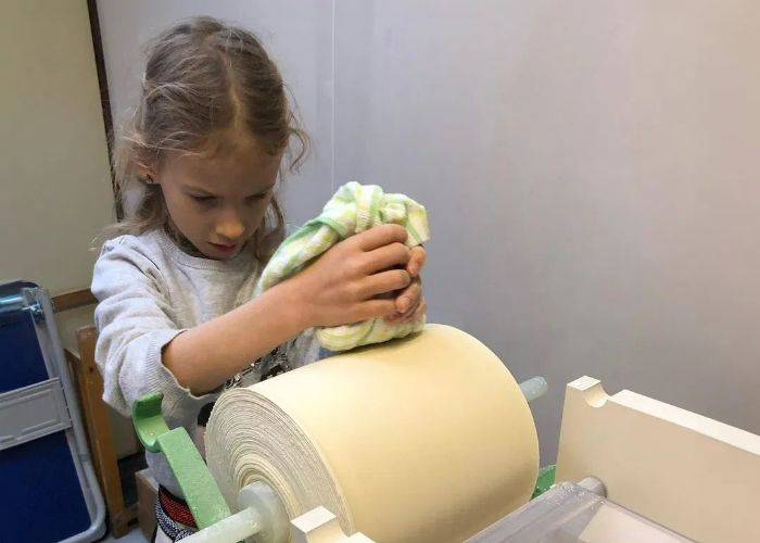 A young girl focusing while making fresh ramen noodles in Kyoto.